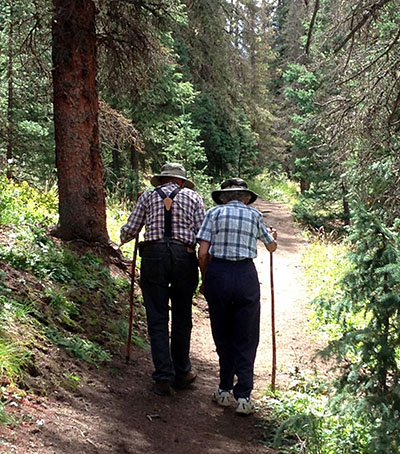 two older adults walk a hiking path side by side